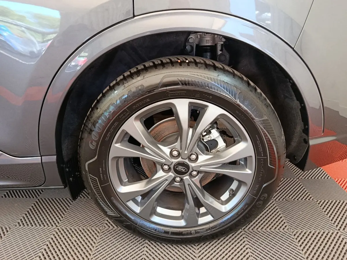 Gros plan sur la roue avant droite gris clair du Ford Kuga 2.0 EcoBlue 2024 avec jante alliage et pneu Goodyear.