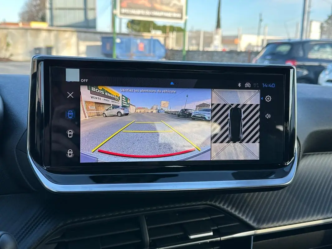 Écran tactile intérieur de la Peugeot 208 Hybrid blanc montrant la caméra de recul et vue 360° du véhicule.