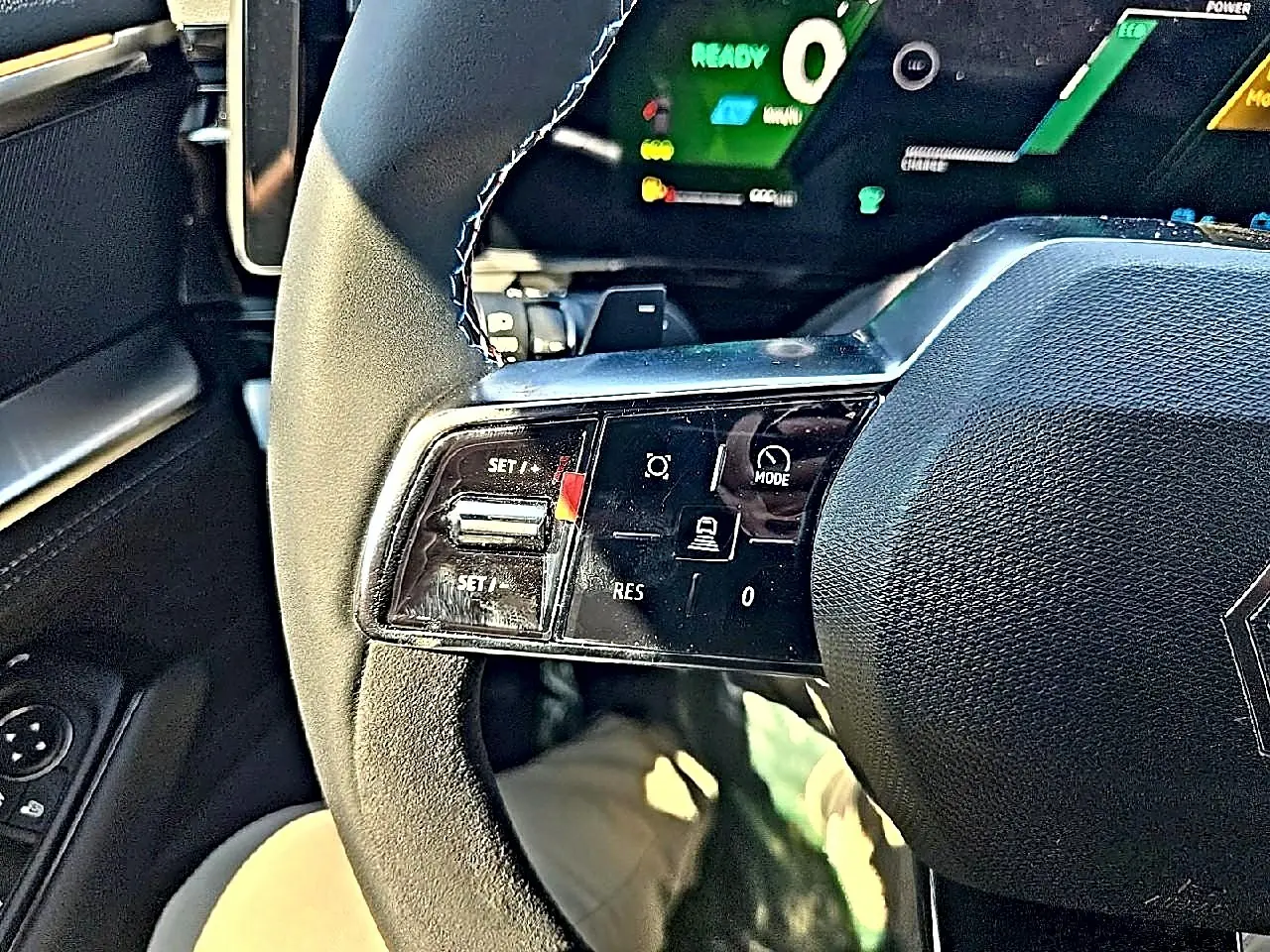 Gros plan sur le volant noir de la Renault Austral blanc nacre, avec commandes multifonctions visibles côté gauche.