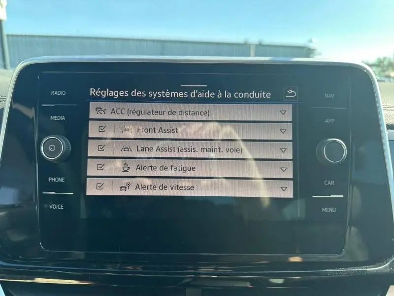 Écran tactile central du Volkswagen T-Roc 2025 affichant les réglages des aides à la conduite.