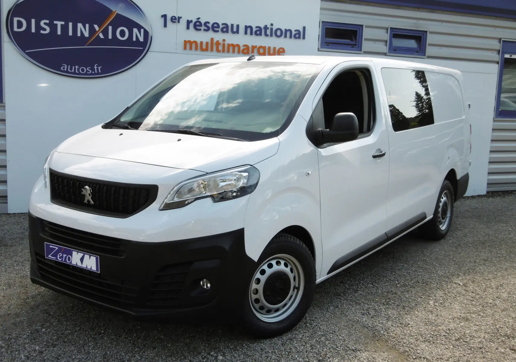 Vue 3/4 avant droite d'un Peugeot Expert cabine approfondie blanc 2023 avec calandre noire et jantes acier.