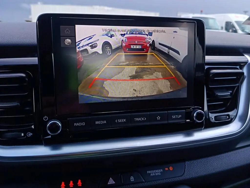 Écran central du Kia Stonic 2022 montrant la caméra de recul avec vue arrière et lignes de guidage colorées.