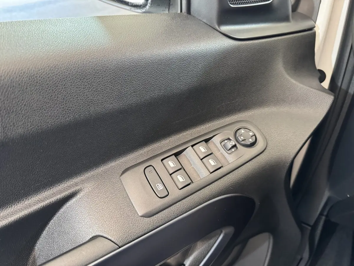 Gros plan sur la commande des vitres et rétroviseurs côté conducteur du Peugeot Rifter blanc, version 2019.