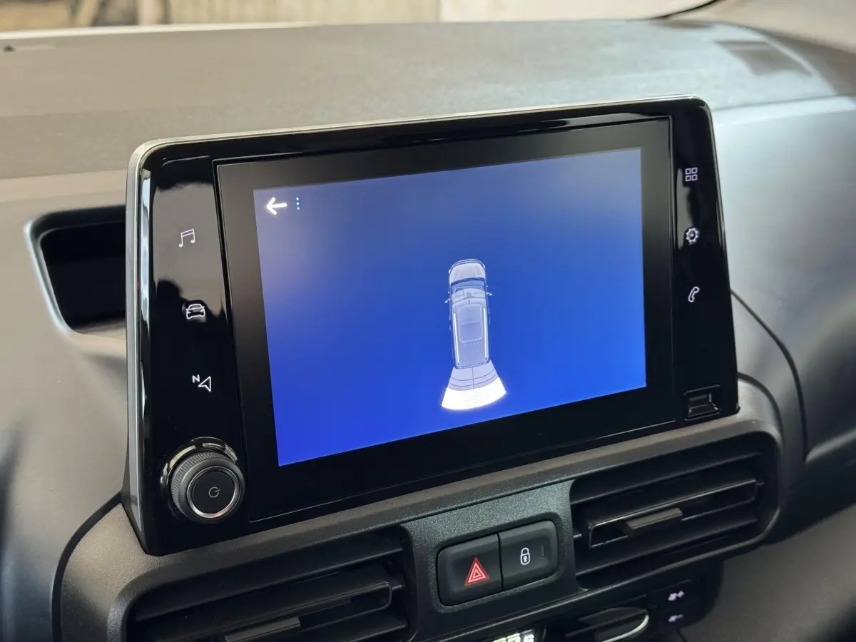 Écran tactile central du tableau de bord du Peugeot Rifter BlueHDi 100 Allure, affichant l'aide au stationnement.