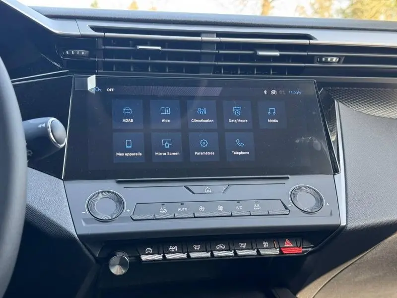 Vue rapprochée de l’écran tactile central et des commandes de climatisation de la Peugeot 308 blanche 2025.