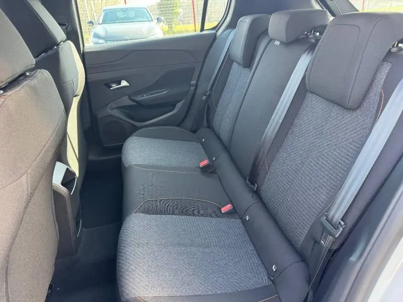 Vue intérieure arrière droite des sièges tissu gris foncé de la Peugeot 308 2025, avec ceintures de sécurité visibles.