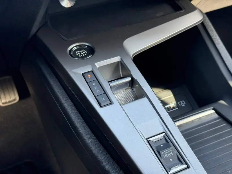 Vue rapprochée de la console centrale grise de la Peugeot 308 2025, avec bouton start/stop et commandes boîte auto.