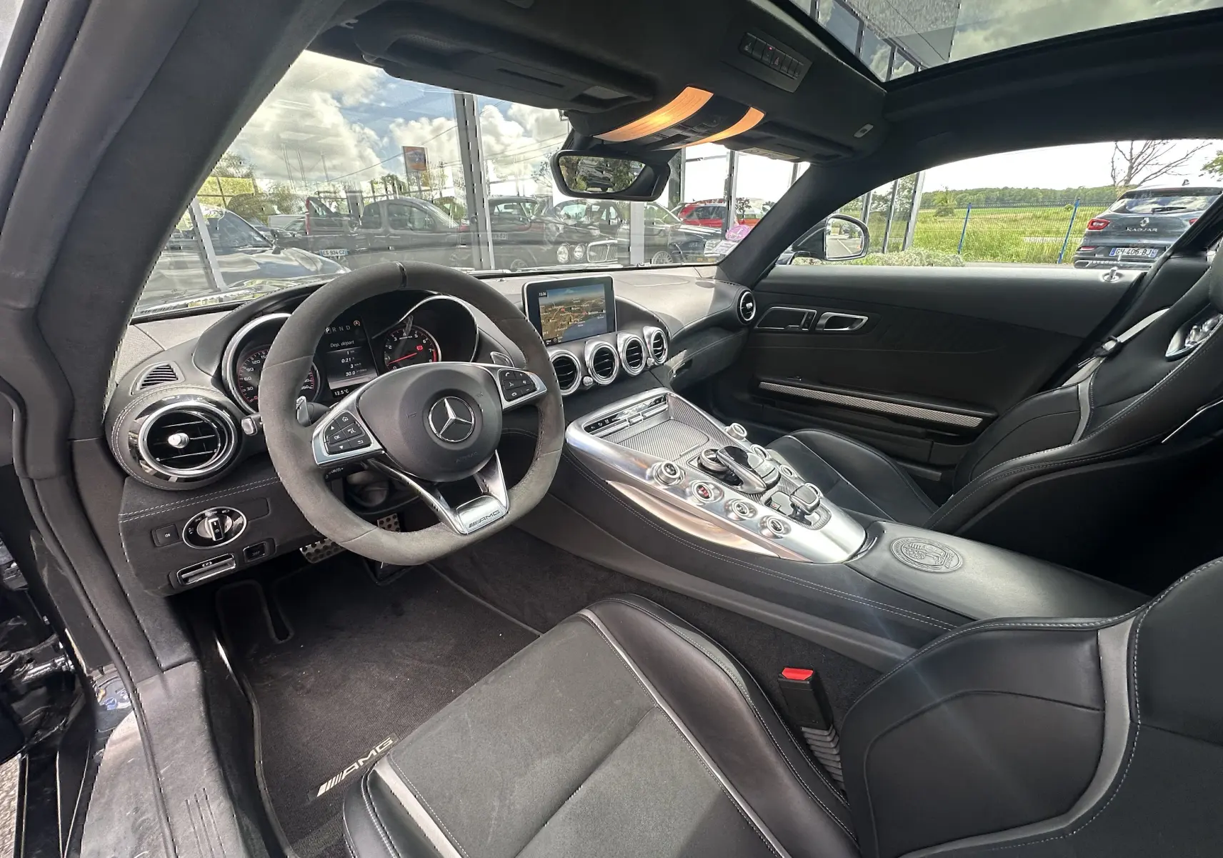 Intérieur noir de la Mercedes AMG GT 2015 vu côté conducteur, avec volant sport et console centrale alu.