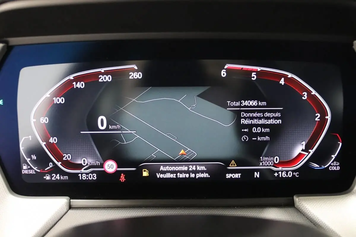 Tableau de bord numérique BMW Série 1 16d 2023 affichant la navigation et l'autonomie restante à 24 km.