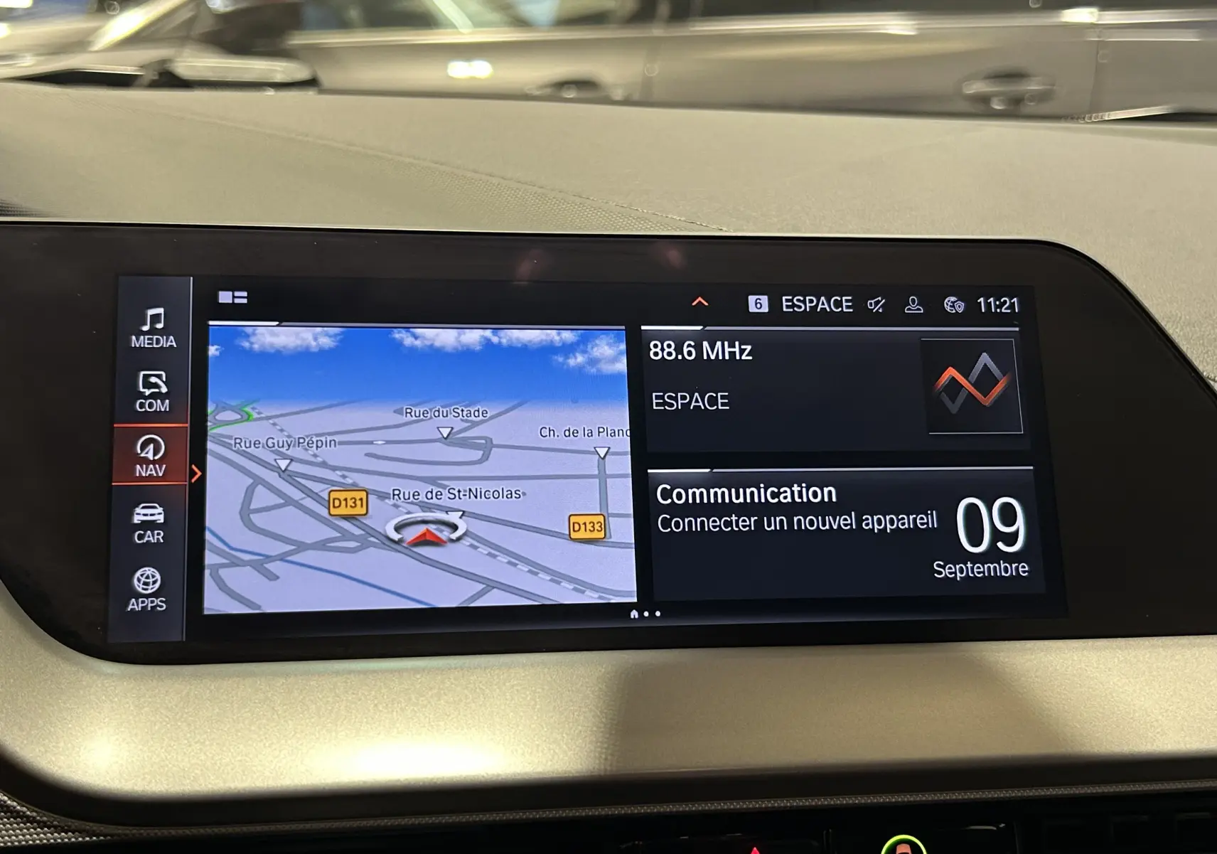 Écran central du tableau de bord de la BMW Série 1 noire 2023 affichant le GPS et les options multimédia.