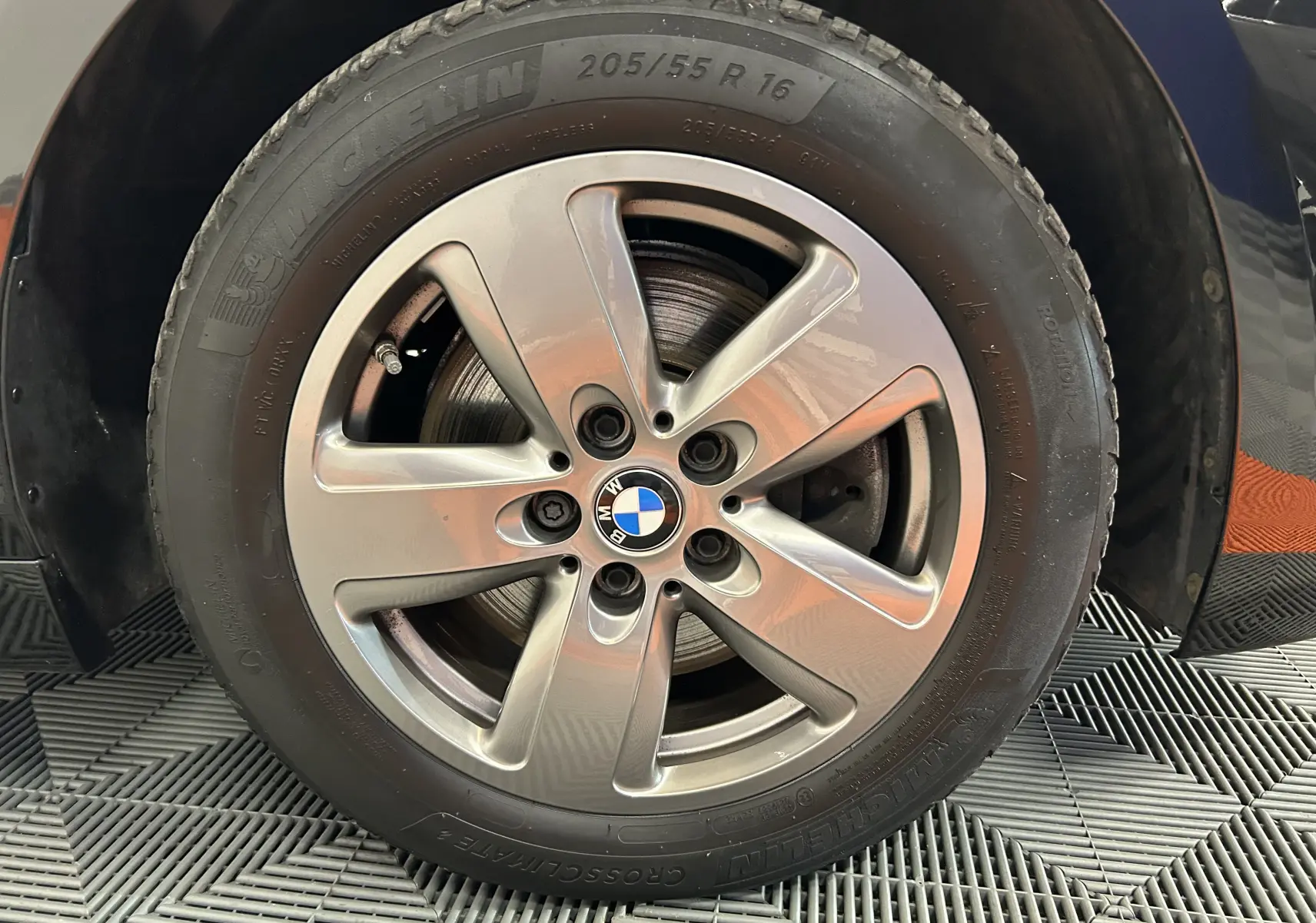 Gros plan sur la jante avant droite en alliage argenté d'une BMW Série 1 noire de 2023 avec pneu Michelin.