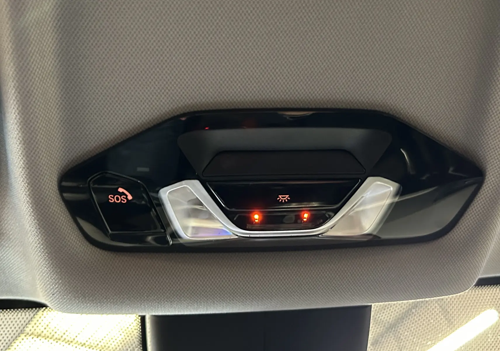 Vue en gros plan du plafonnier noir avec bouton SOS et éclairage intérieur de la BMW Série 1 16d 2023.