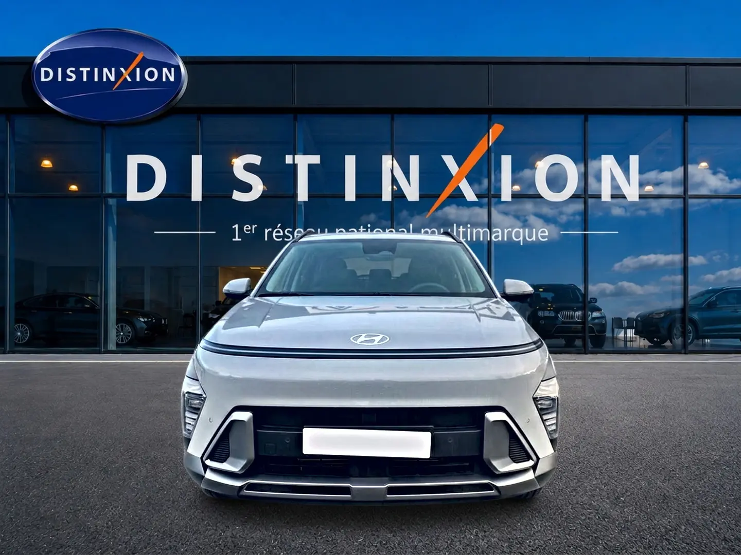 Vue frontale d'un Hyundai Kona gris 2025 avec calandre noire et bande lumineuse LED au-dessus du capot.