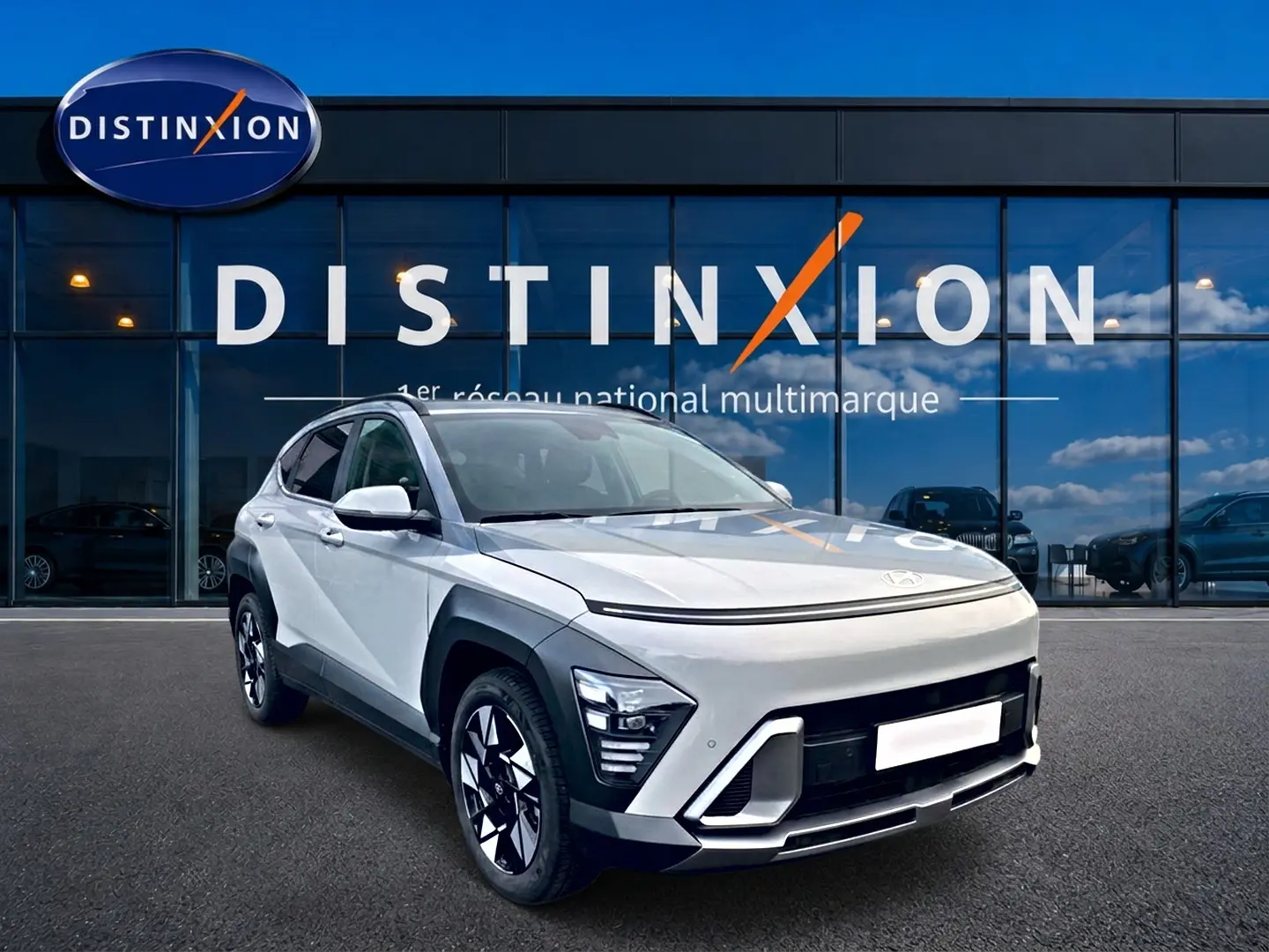Hyundai Kona gris 2025 en 3/4 avant droit, avec jantes alliage et calandre moderne devant showroom Distinxion.