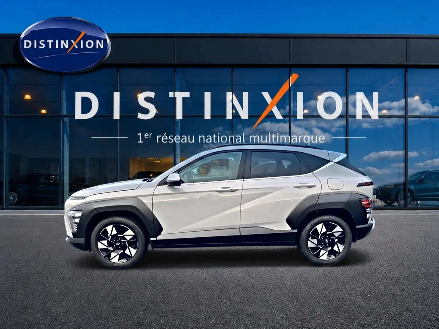 Vue latérale gauche d'un Hyundai Kona gris 2025 avec jantes alliage noires et protections d'ailes noires.