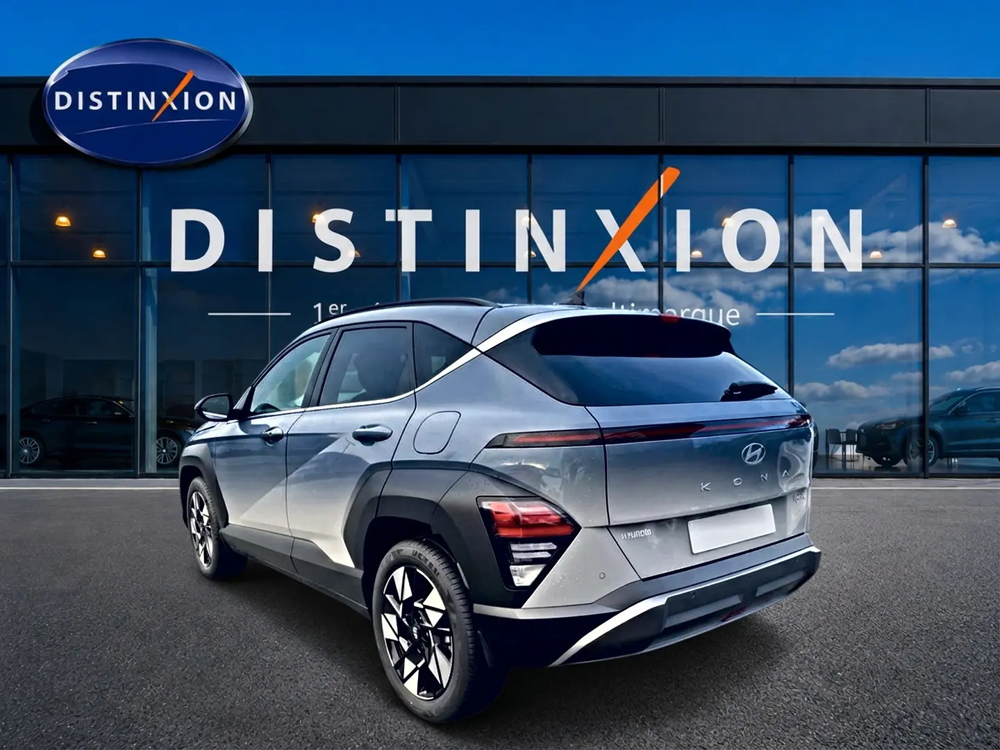 Vue 3/4 arrière droite d'un Hyundai Kona gris 2025 avec feux arrière LED et jantes alliage noires et argentées.