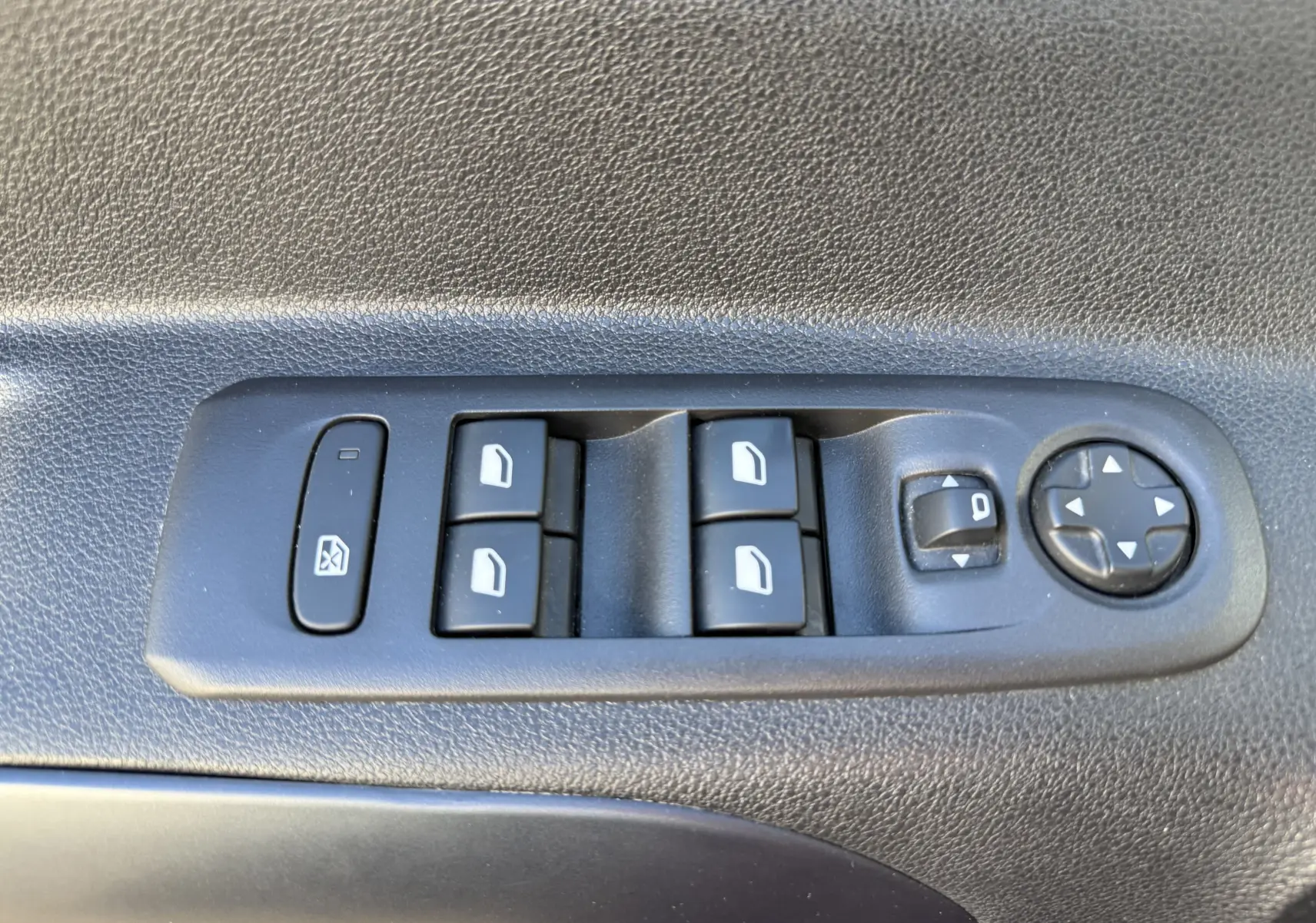 Gros plan sur les commandes de lève-vitres et réglage des rétroviseurs côté conducteur du Peugeot Rifter gris platinium 2020.