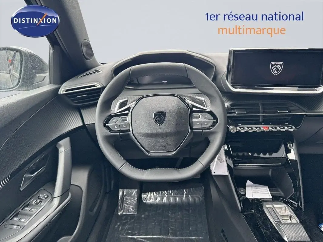 Vue intérieure centrée sur le volant cuir et l'écran tactile du Peugeot 2008 noir, avec détails modernes et commandes intégrées.