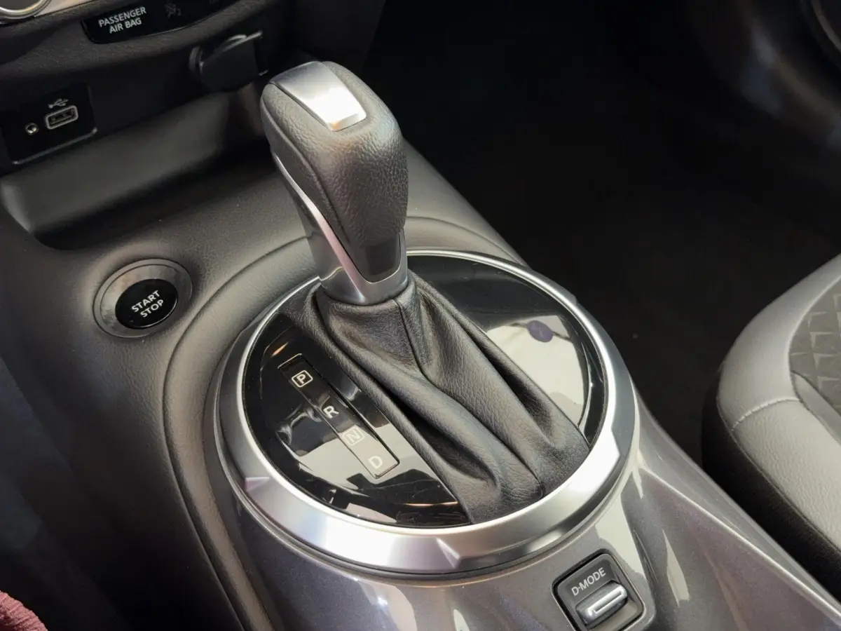 Gros plan sur le levier de vitesses automatique gris foncé du Nissan Juke 2023, avec bouton start/stop visible.