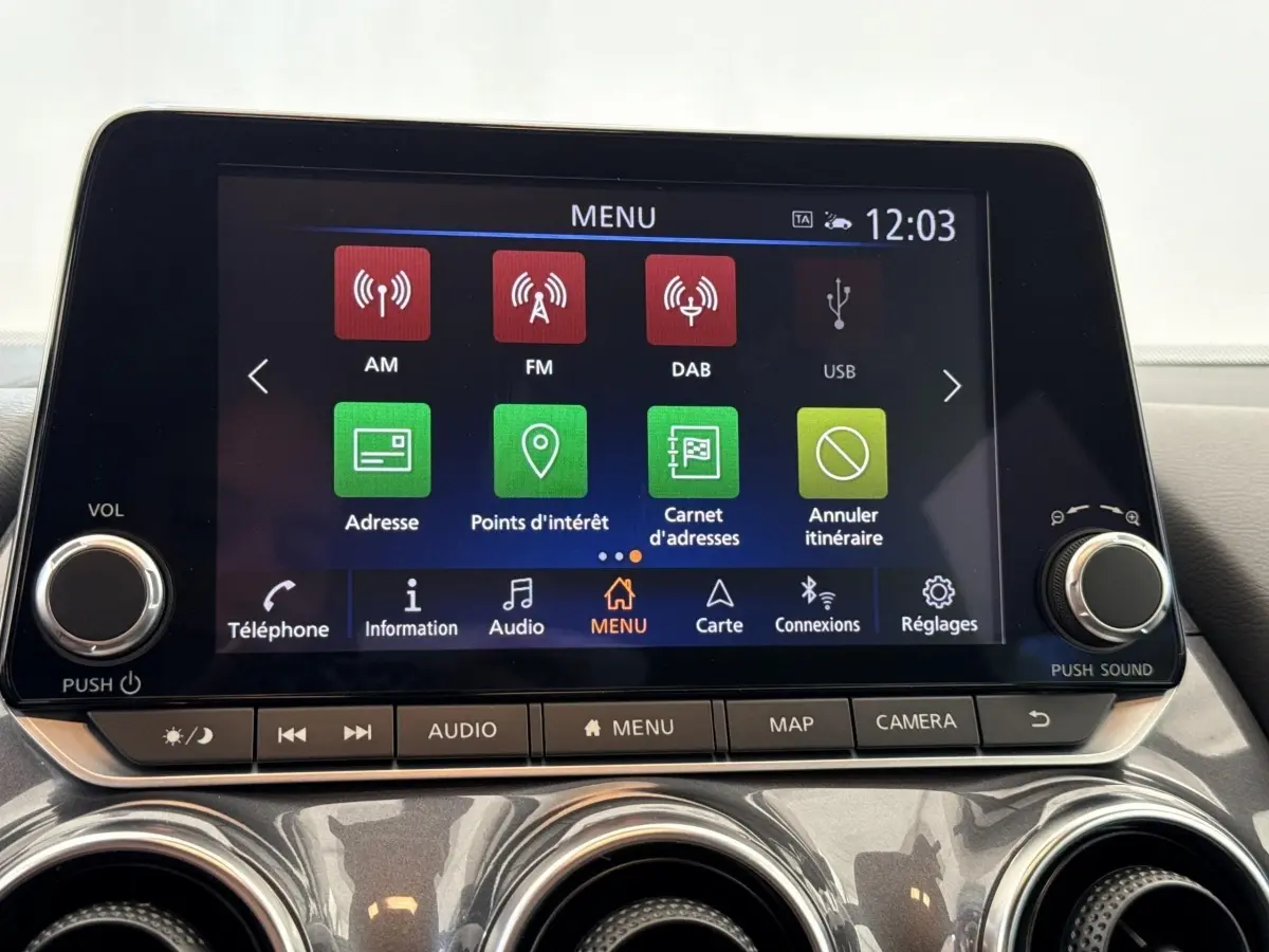 Écran tactile central du tableau de bord du Nissan Juke gris foncé 2023 affichant le menu de navigation.