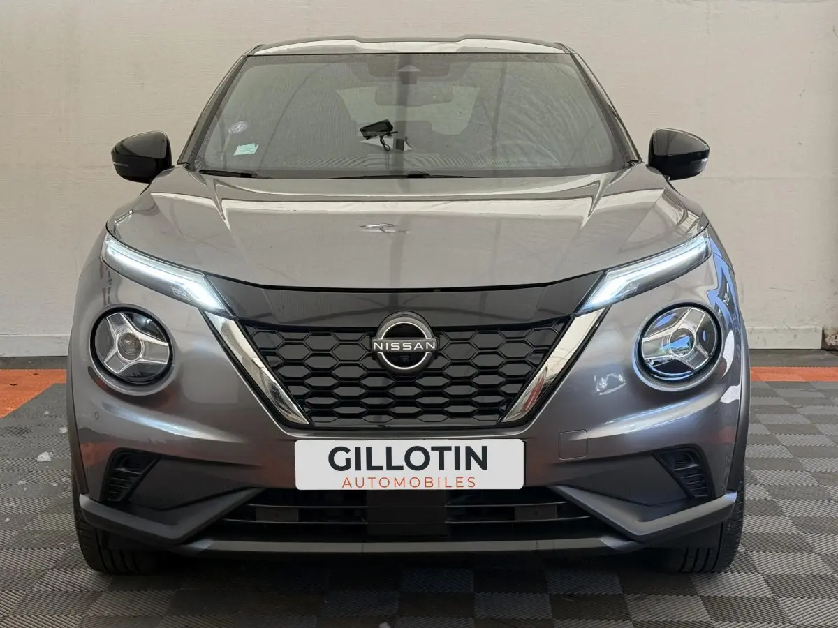 Vue frontale d’un Nissan Juke gris foncé 2023 avec phares LED et calandre noire à motifs hexagonaux.