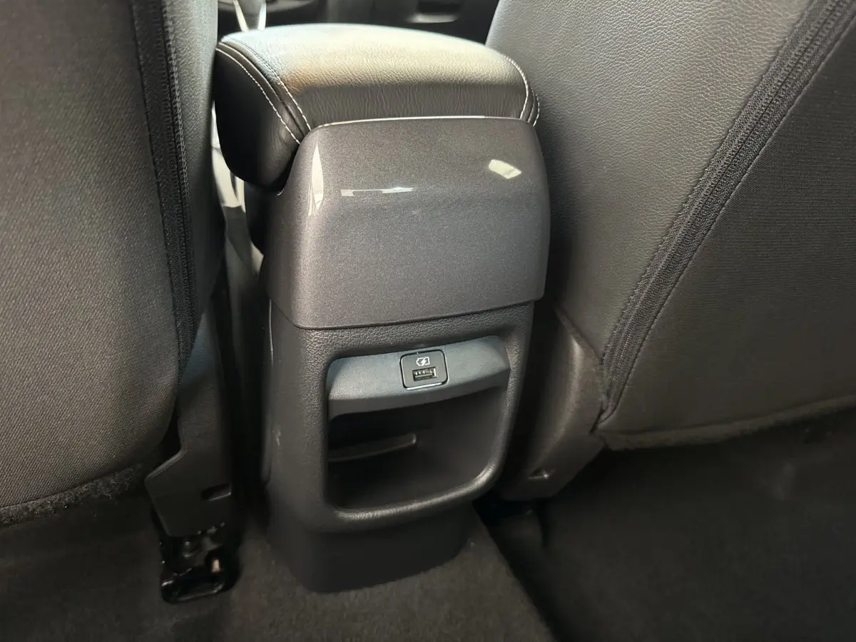 Vue rapprochée de la console arrière entre les sièges noirs du Nissan Juke 2023, avec port USB visible.