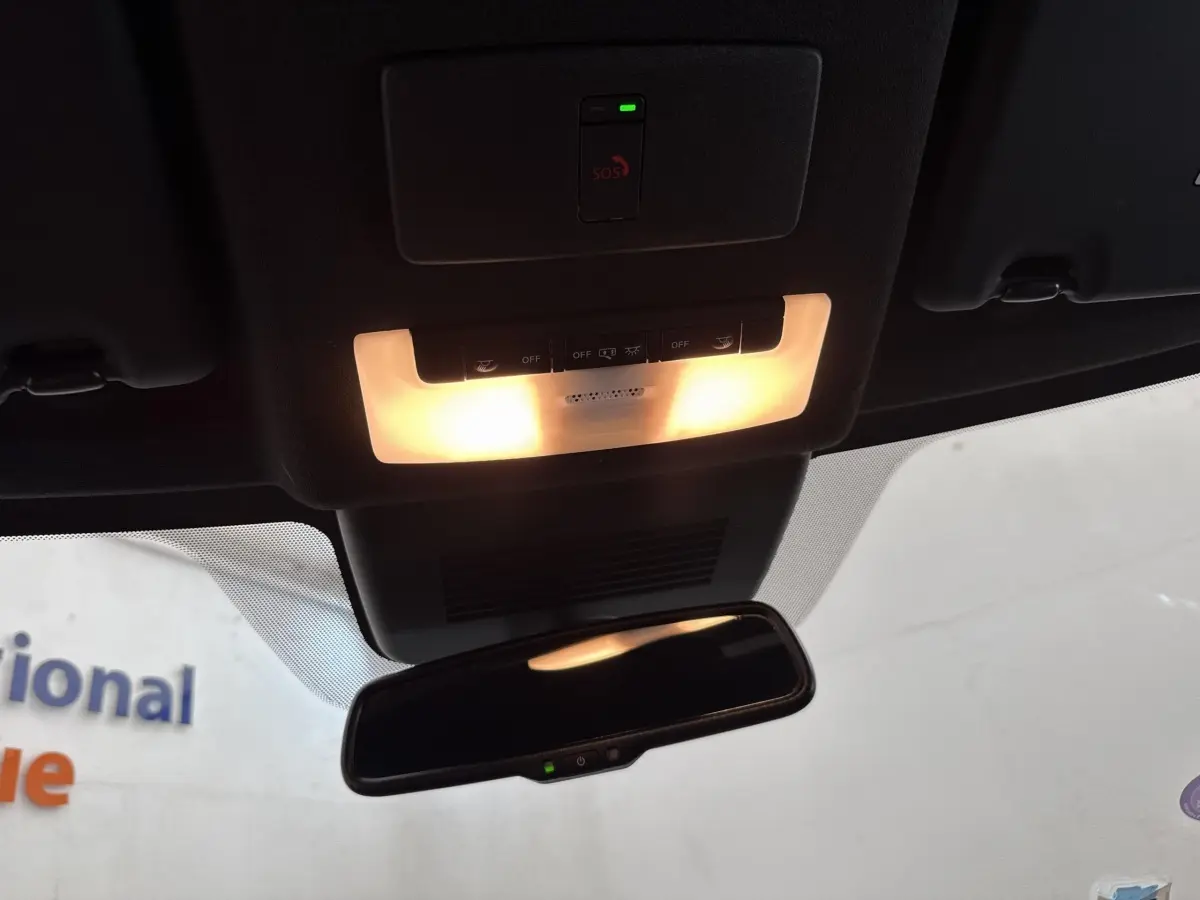 Vue intérieure du plafonnier et du rétroviseur intérieur du Nissan Juke gris foncé 2023 avec éclairage activé.