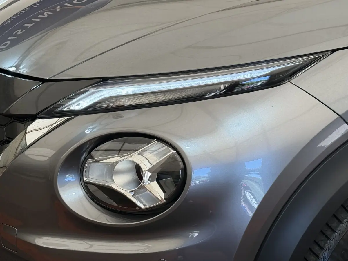 Gros plan sur le phare avant droit du Nissan Juke 2023 gris foncé, mettant en valeur son design LED distinctif.