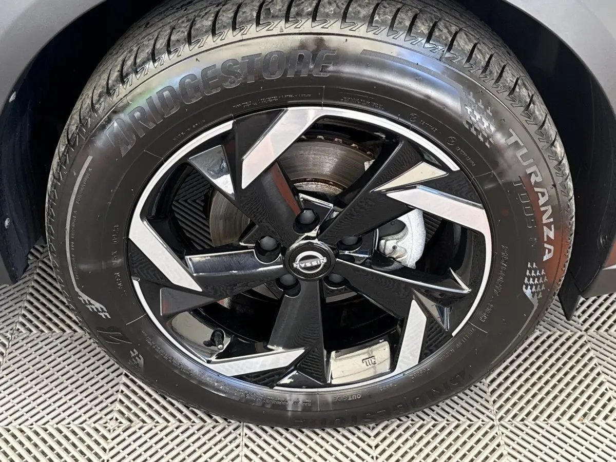 Gros plan sur la roue avant droite du Nissan Juke 2023, jante alliage noire et argent avec pneu Bridgestone Turanza.