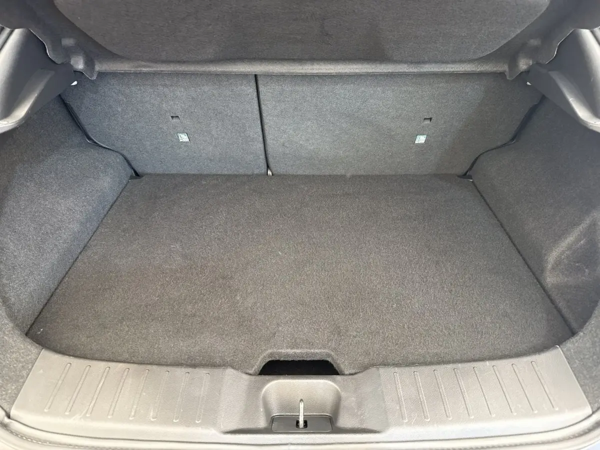 Coffre spacieux gris foncé du Nissan Juke 2023, vue intérieure arrière avec banquette rabattue et plancher plat.