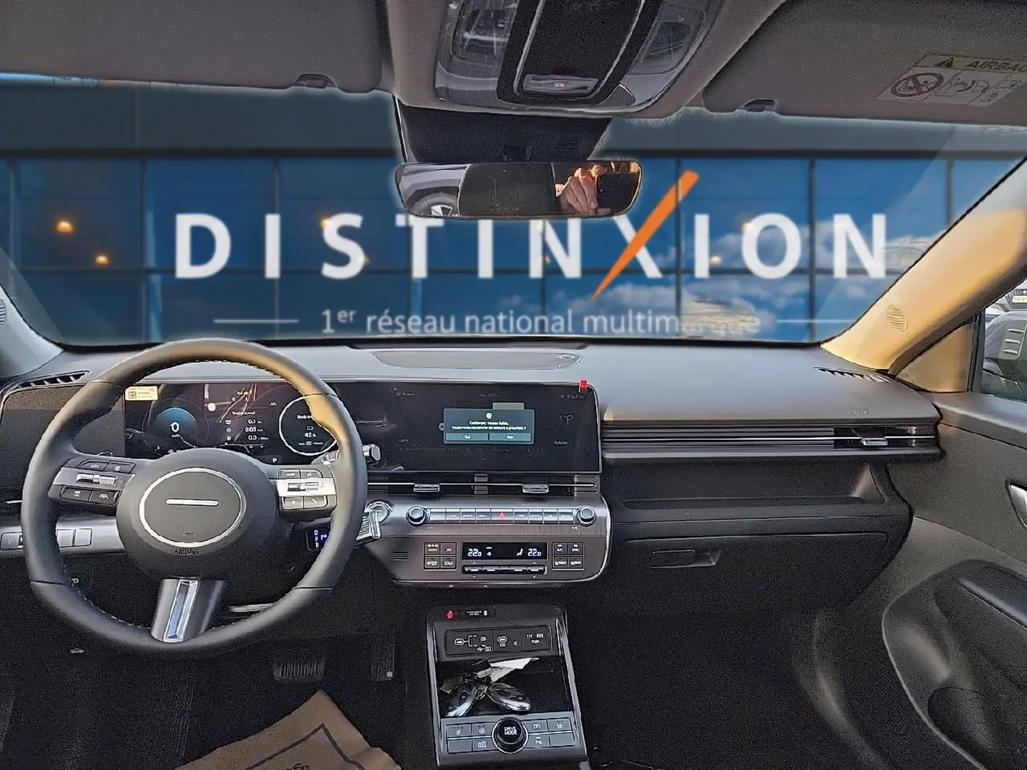 Vue intérieure avant du Hyundai Kona 2025 gris ecotronic avec tableau de bord numérique et volant multifonction cuir.
