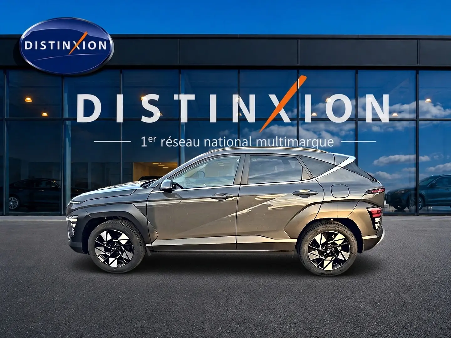 Profil droit d’un Hyundai Kona gris ecotronic 2025 avec jantes alliage noires et détails anguleux marqués.