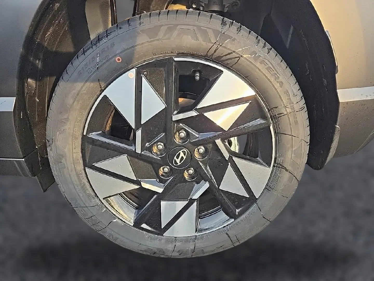 Gros plan sur la jante alliage 18 pouces noire et argentée du Hyundai Kona gris Ecotronic, vue latérale côté gauche.