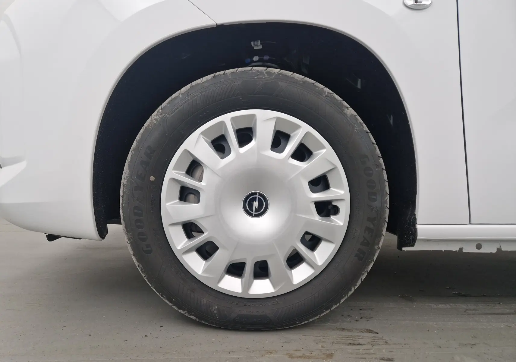 Gros plan sur la roue avant gauche blanche d'un Opel Combo Life M 1.5 BlueHDi avec jante et logo Opel visibles.