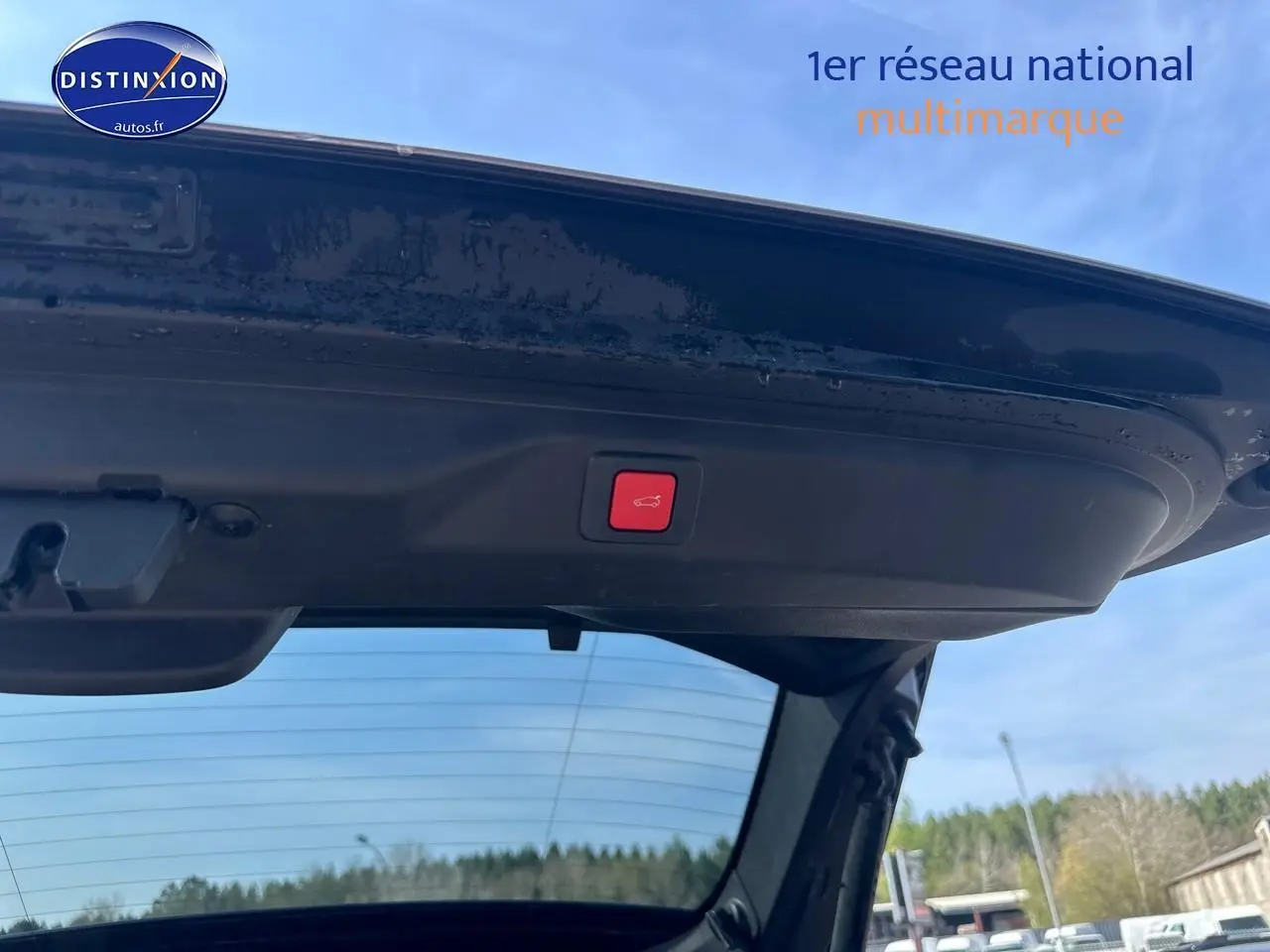 Vue intérieure du hayon ouvert du Peugeot 3008 gris Artense, montrant le bouton de fermeture électrique sous le toit du coffre.