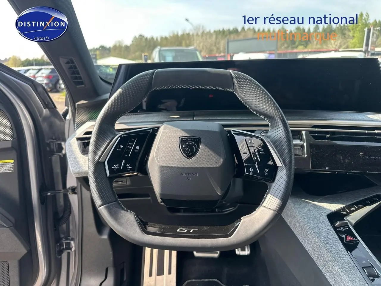 Vue intérieure centrée sur le volant cuir GT du Peugeot 3008 gris Artense, avec tableau de bord et commandes visibles.