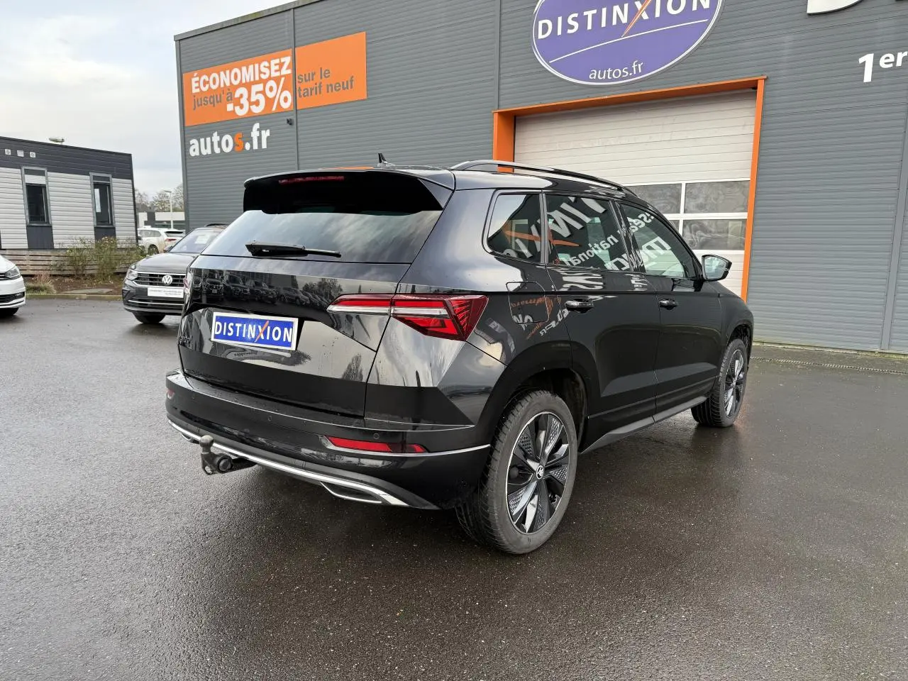 Vue 3/4 arrière droite d'un Skoda Karoq noir Magic nacré avec crochet d'attelage et jantes alliage noires.