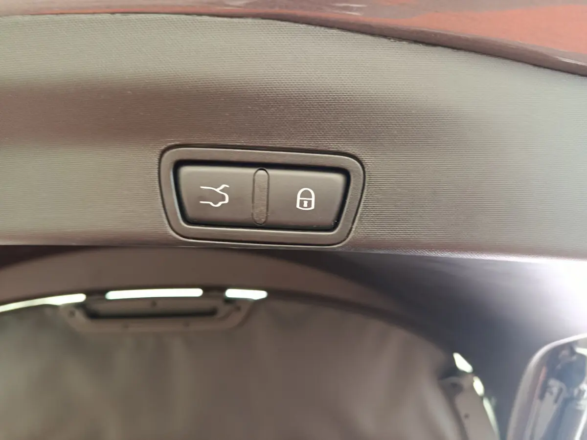 Gros plan sur les boutons d'ouverture et de verrouillage électrique du coffre d'un Alfa Romeo Stelvio gris foncé 2024.