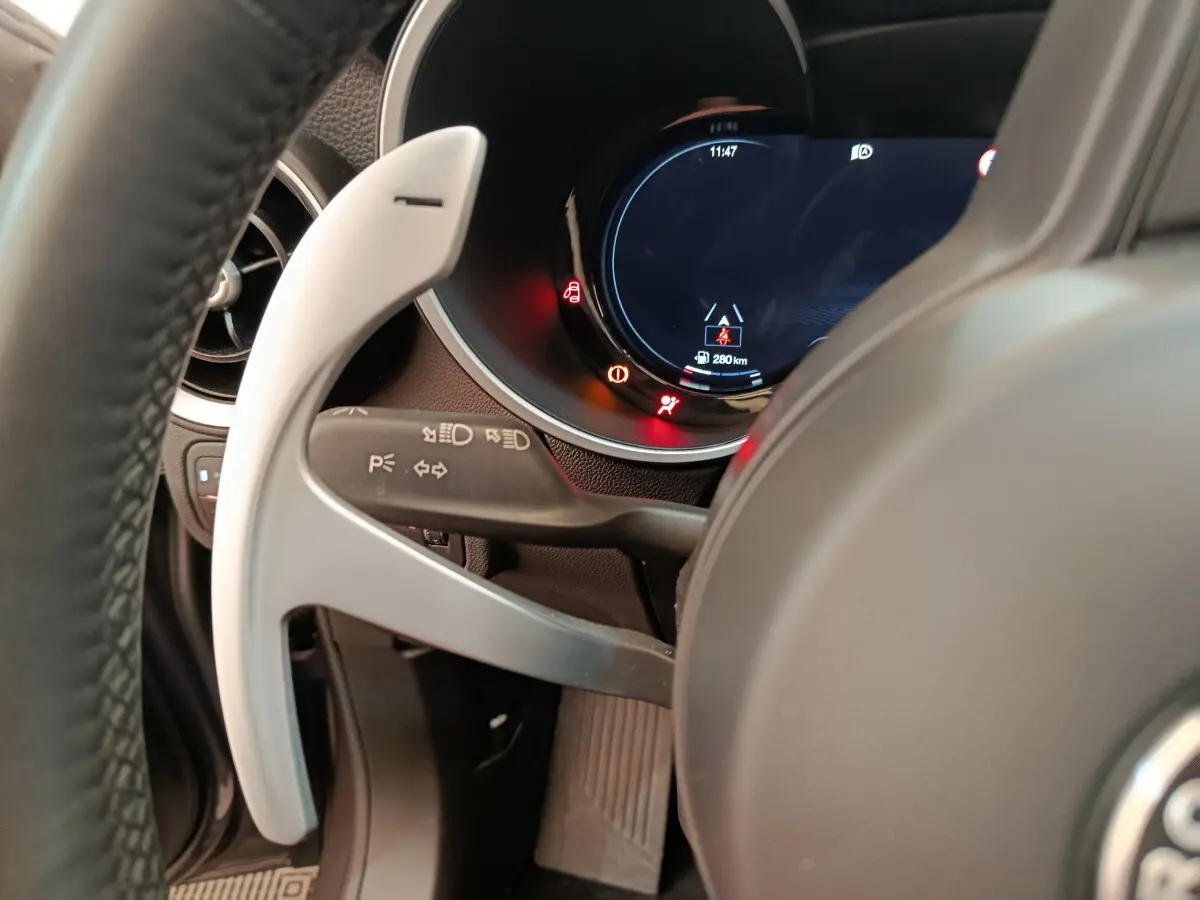 Gros plan sur le volant et le combiné d'instruments digital de l'Alfa Romeo Stelvio gris foncé, côté conducteur.