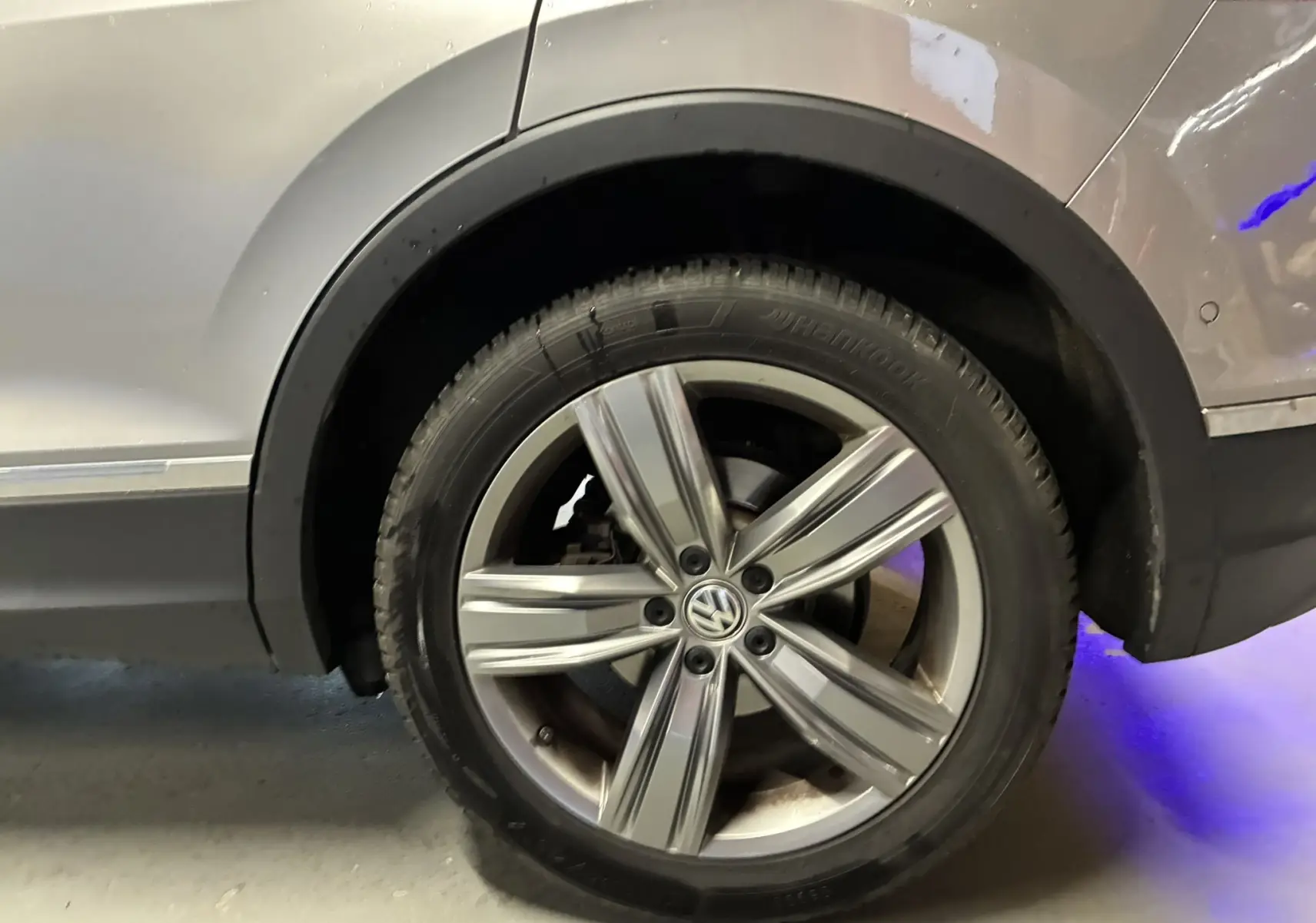 Gros plan sur la roue arrière droite gris métallisé d’un Volkswagen Tiguan 2.0 TDI 150 Carat de 2017 avec jante alliage 19 pouces.