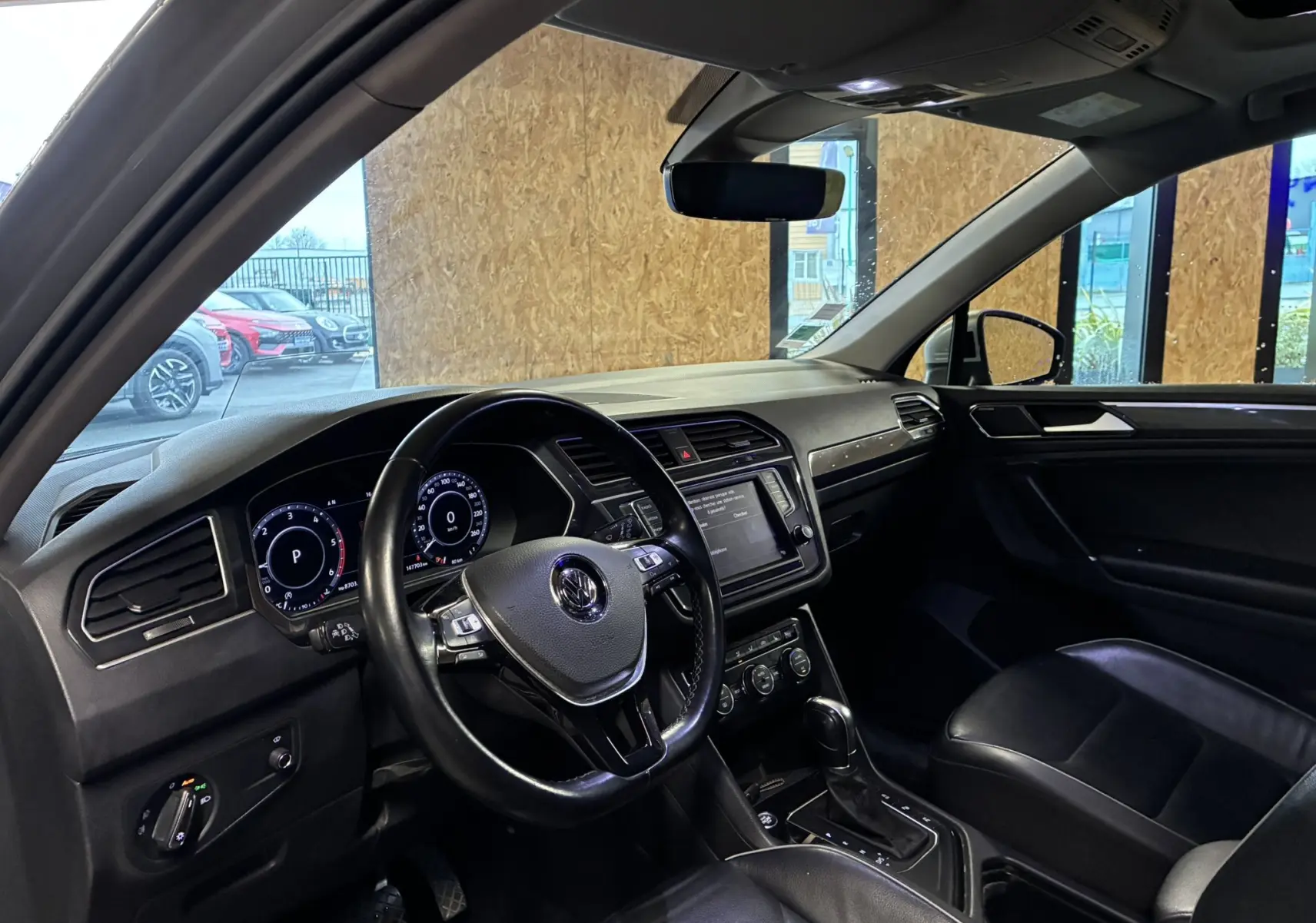 Intérieur noir du Volkswagen Tiguan 2.0 TDI 150 Carat 2017, vue côté conducteur sur tableau de bord et volant cuir.