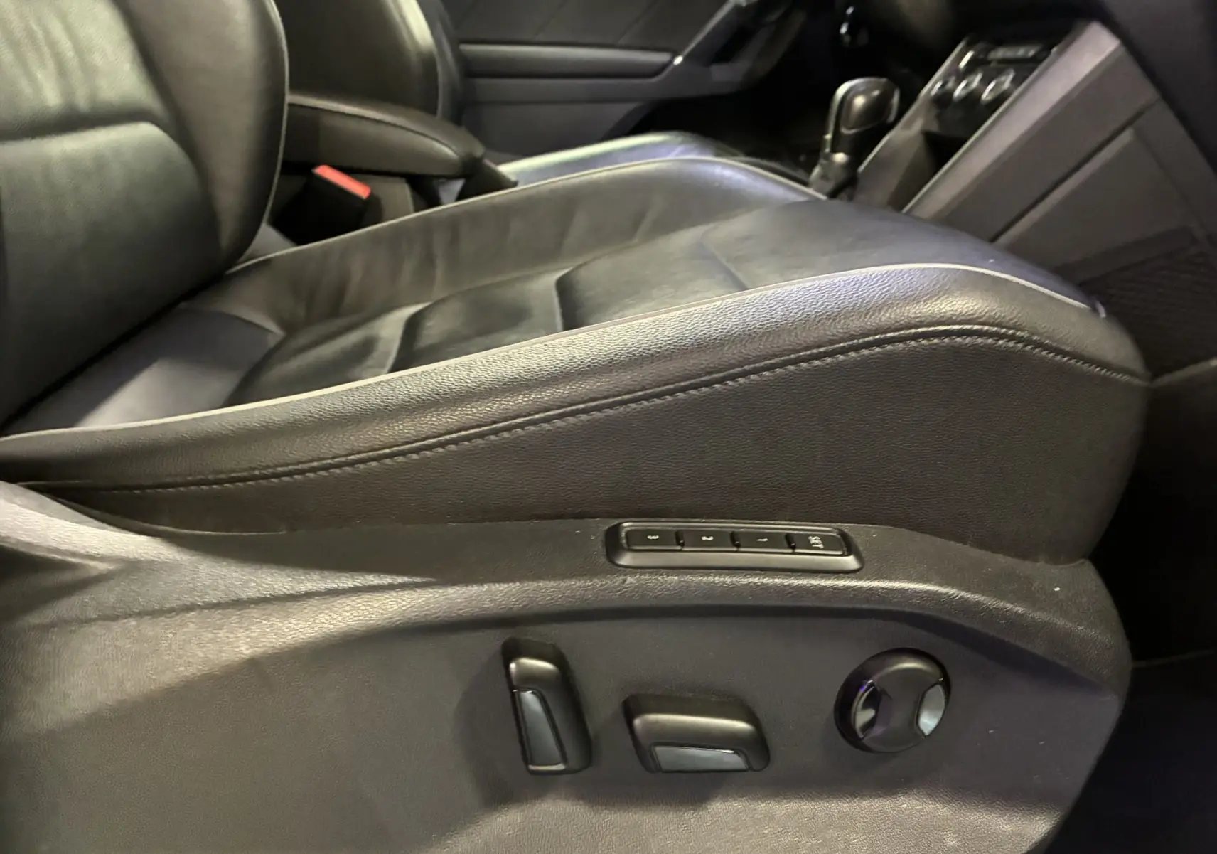 Gros plan sur le siège conducteur en cuir noir avec réglages électriques et mémoire dans le Volkswagen Tiguan gris 2017.