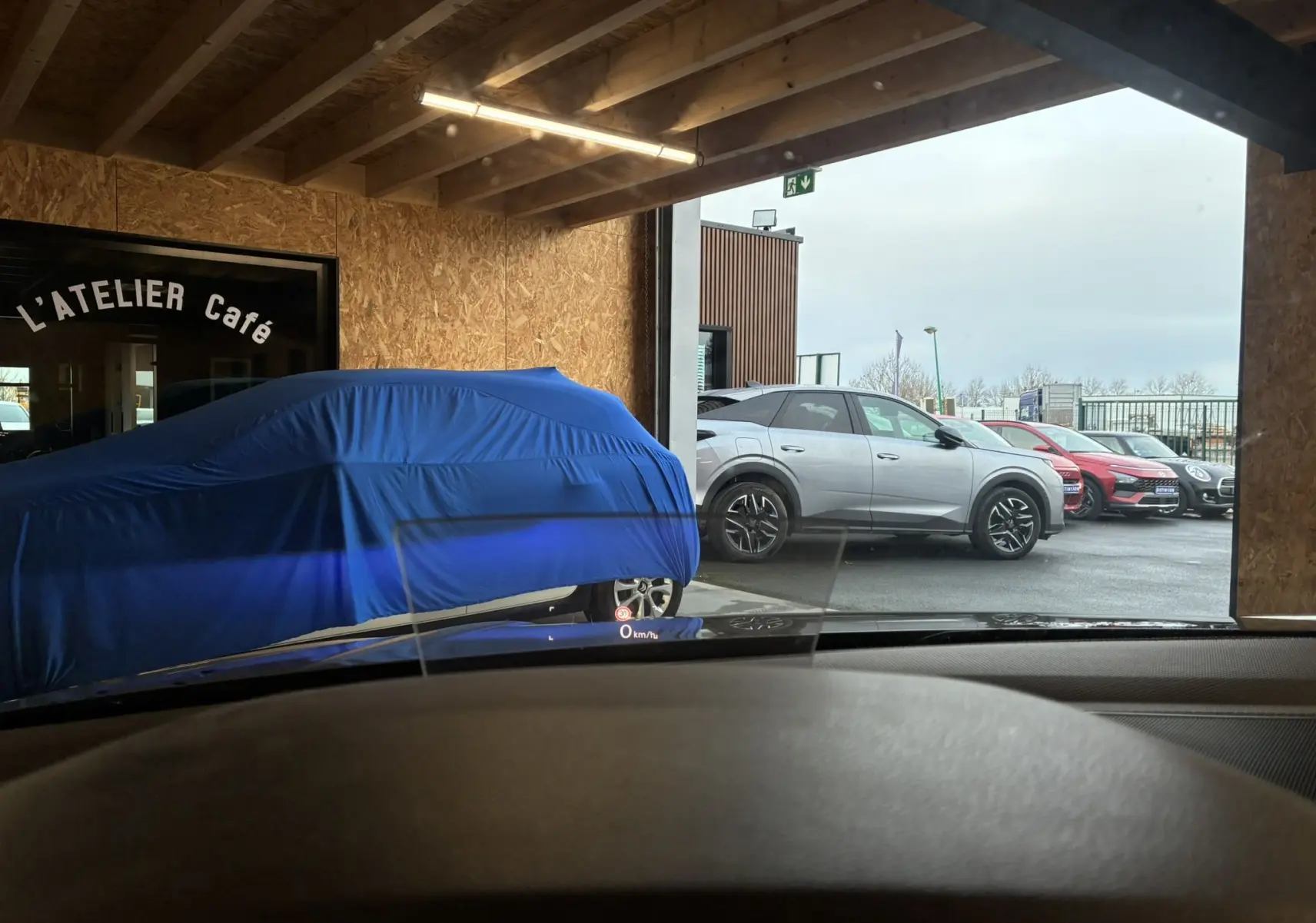 Vue latérale droite d'un Volkswagen Tiguan gris stationné à l'extérieur, avec jantes noires et toit noir contrastant.