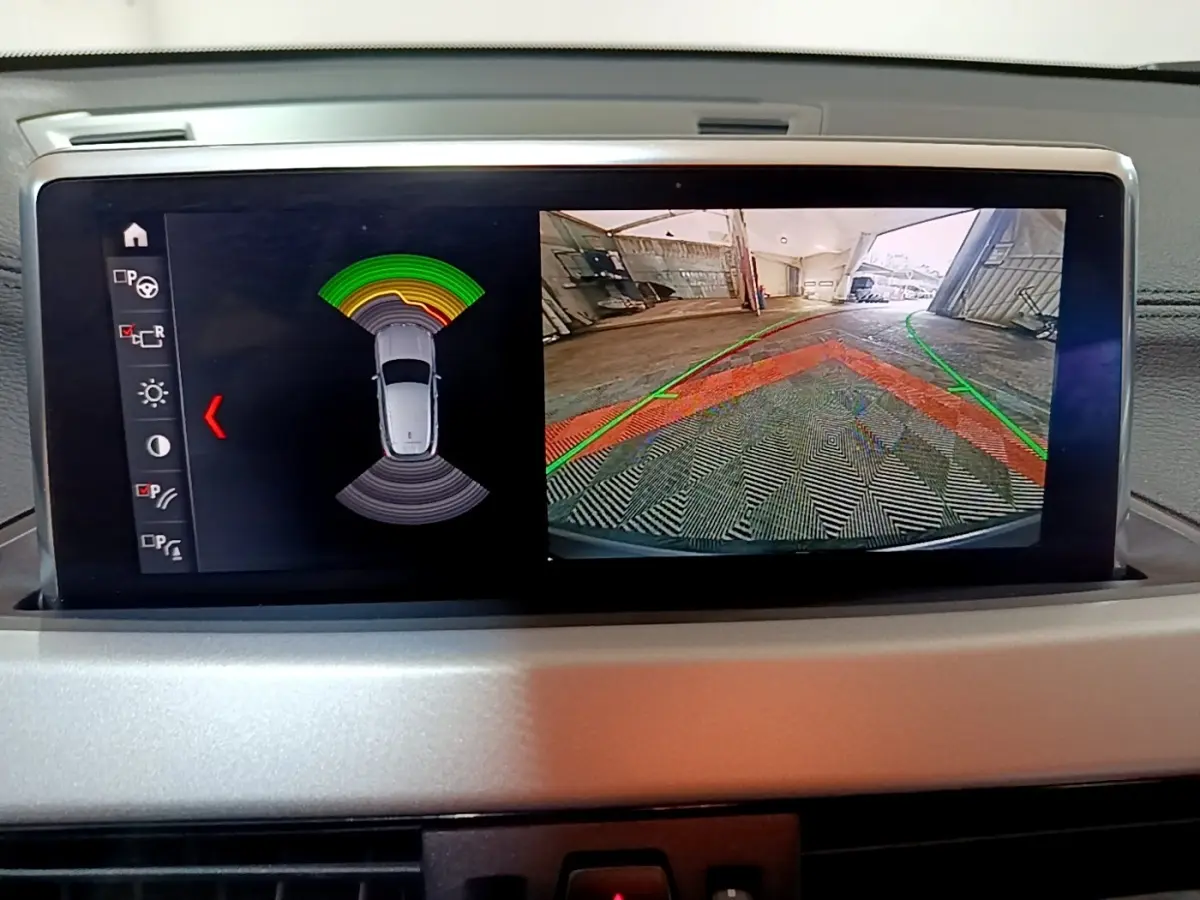 Affichage écran intérieur BMW X2 sDrive18i 2021 montrant caméra de recul et capteurs de stationnement.
