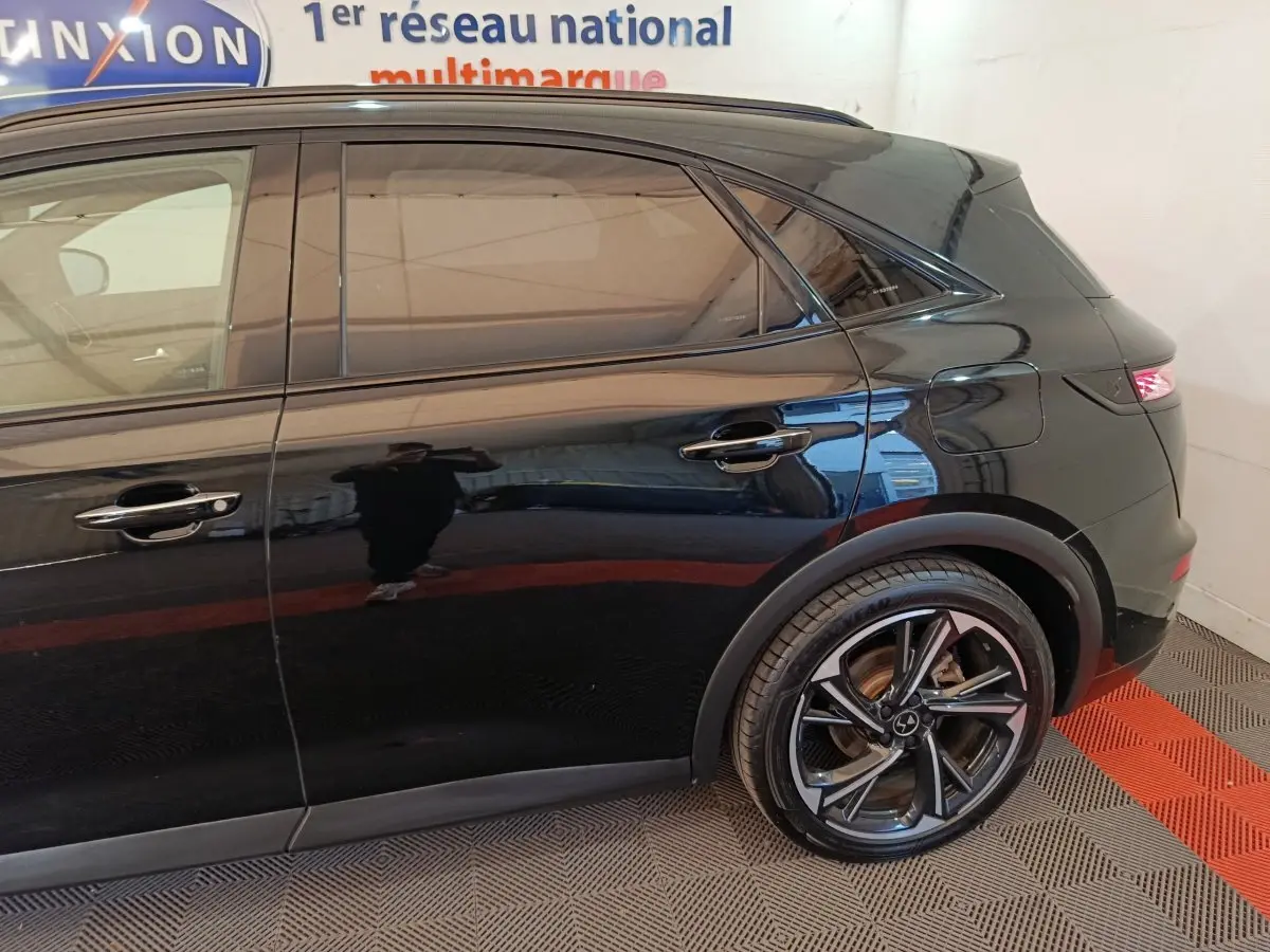 Vue latérale droite du DS7 Crossback noir, mettant en valeur la porte arrière et la roue arrière au design moderne.