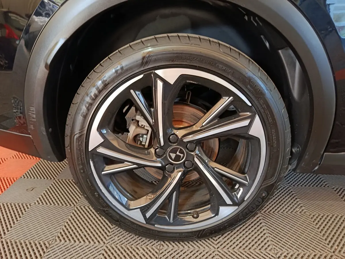 Gros plan sur la roue avant droite noire du DS7 Crossback E-TENSE 4x4 300 LOUVRE avec jante alliage bicolore.