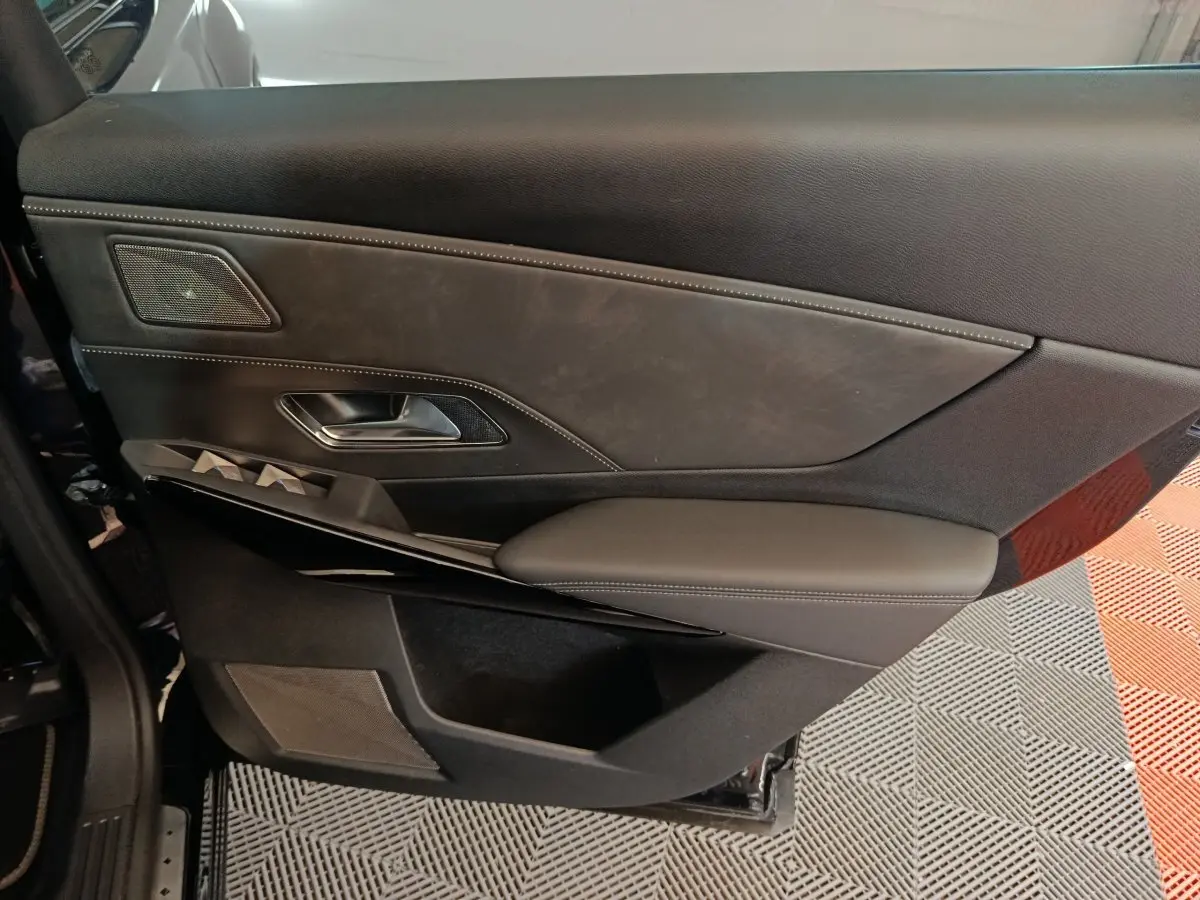 Gros plan sur la porte intérieure côté gauche du DS7 Crossback E-TENSE 4x4 300 noir, avec garniture cuir et commandes intégrées.