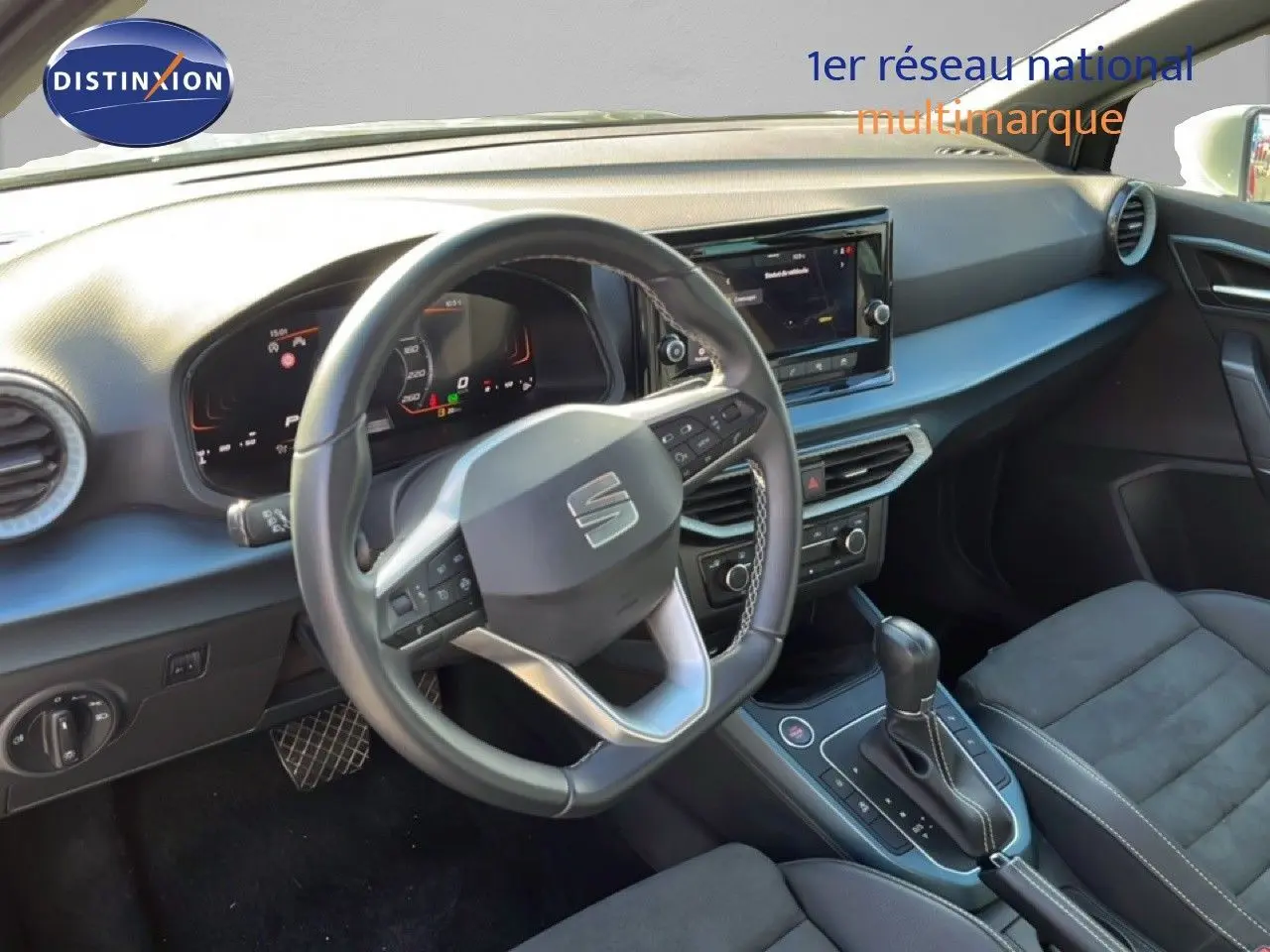 Vue intérieure du poste de conduite de la SEAT Arona 2025, volant cuir et tableau de bord numérique, ambiance noire élégante.