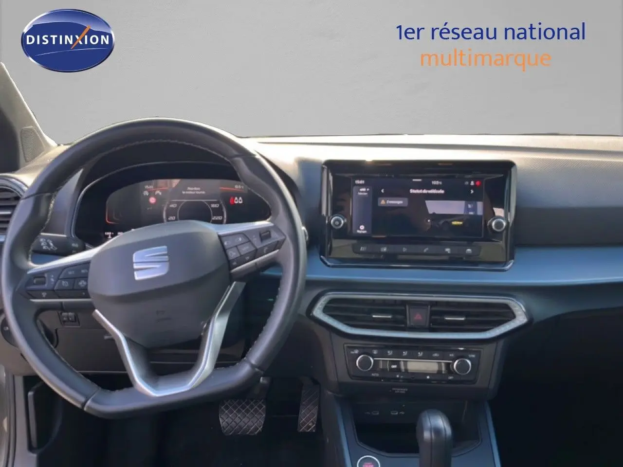 Vue intérieure frontale du tableau de bord du SEAT Arona gris magnétique, avec volant multifonction et écran tactile central.