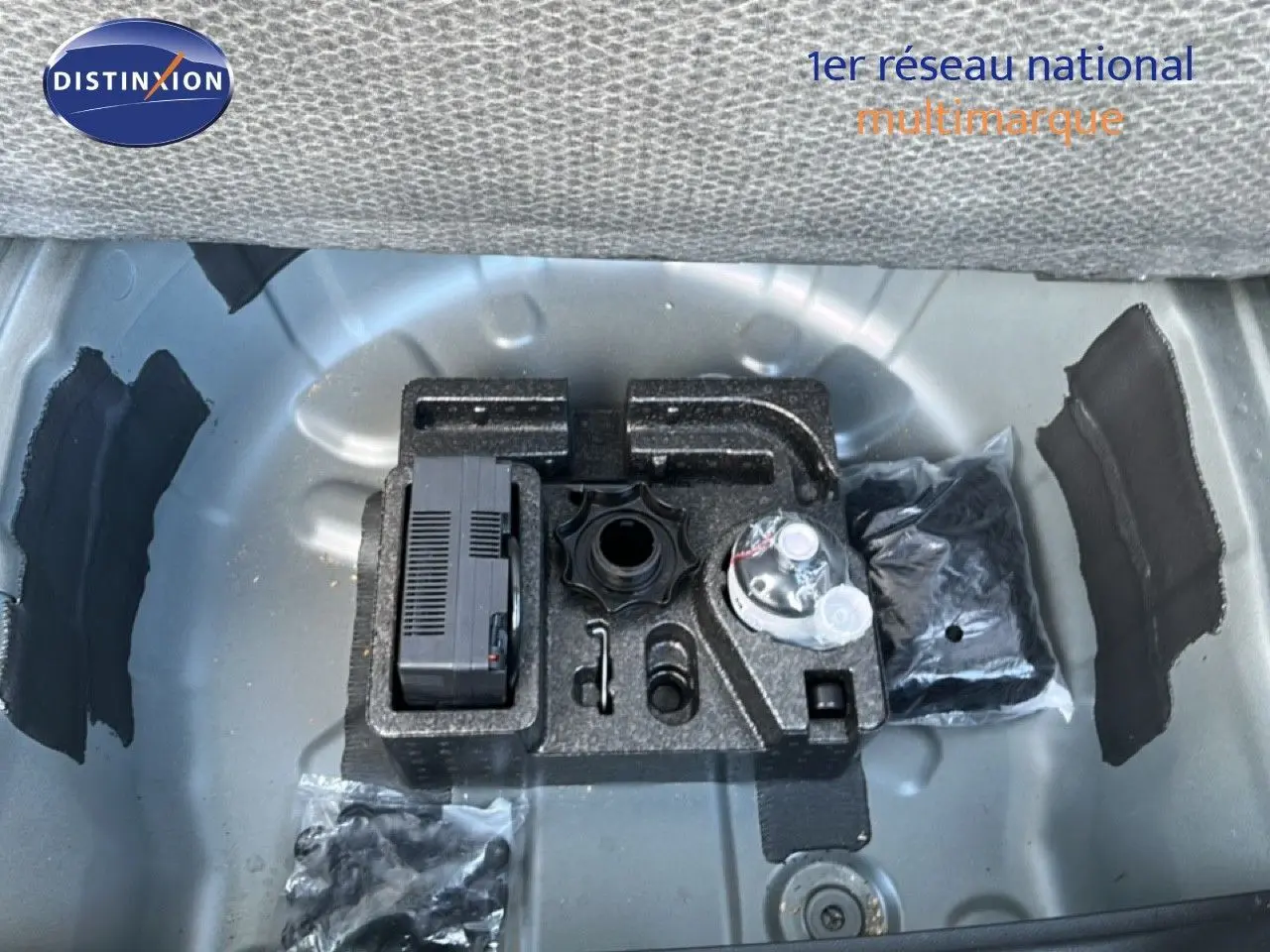 Coffre ouvert montrant le rangement sous plancher avec kit de réparation et accessoires du SEAT Arona gris métallique.